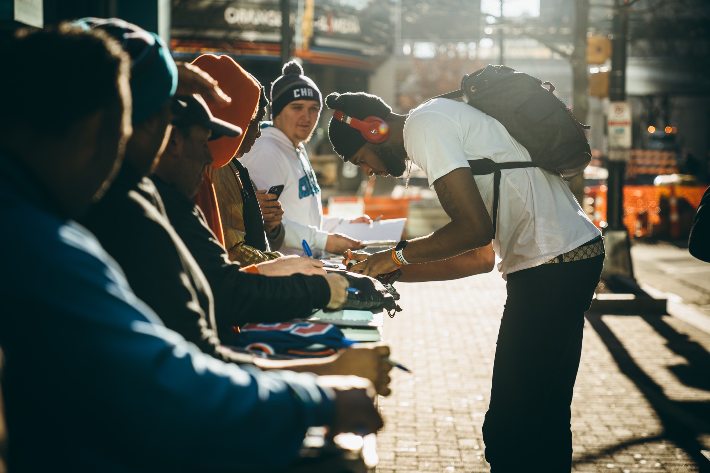 Player signing autographs outside arena